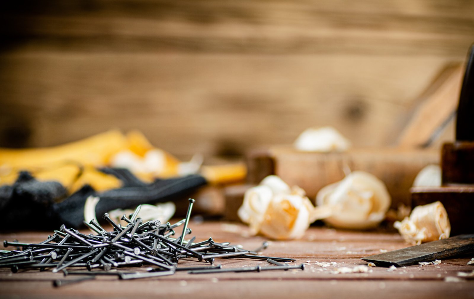 A pile of nails on the table. On a wooden background. High quality photo