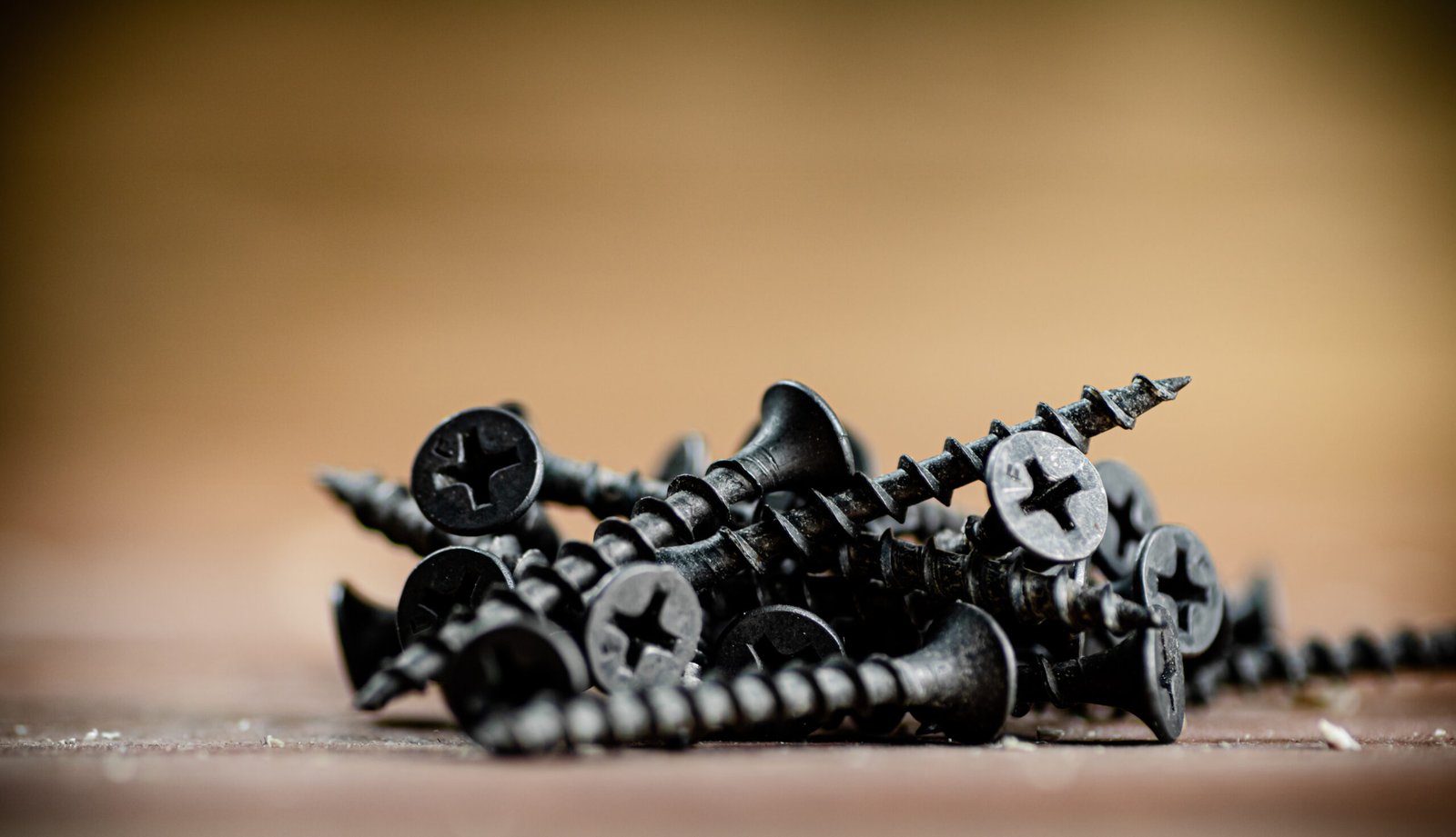 Self-tapping screws on the table. On a wooden background. High quality photo